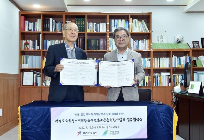 이재정 경기도교육감(사진 오른쪽)과 염무웅 겨레말큰사전남북공동편찬사업회 이사장이 서로 서명한 협약서를 들어보이고 있다. (사진 = 경기도교육청 제공)