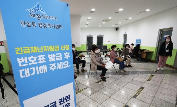 지난 5월 19일 오후 세종시 한솔동 행정복지센터에서 주민들이 긴급재난지원금을 신청하기 위해 거리 두기를 유지한 채 자리하고 있다. (사진=연합뉴스)