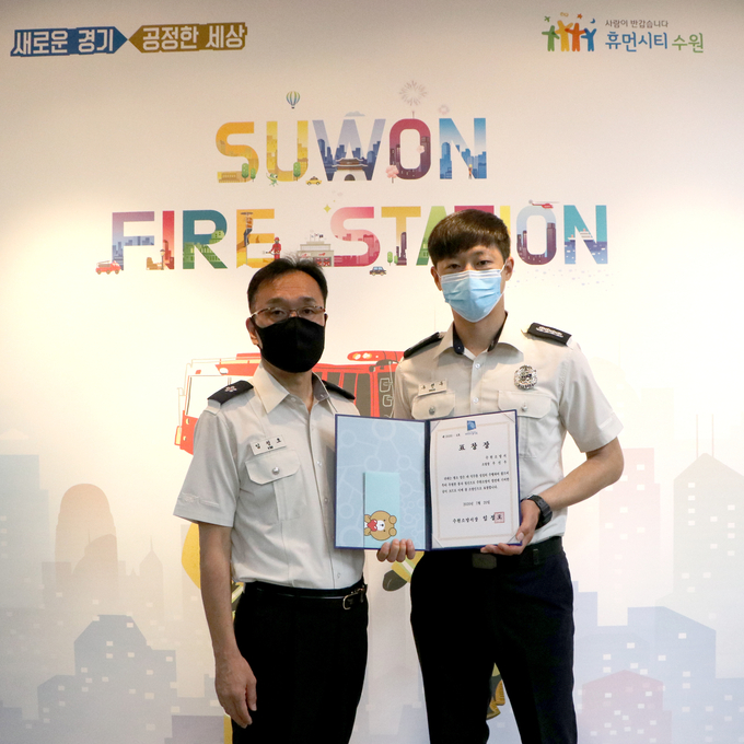 2020 상반기 '참 소방인'에 선정된 우선우(오른쪽)소방장이 임정호(왼쪽)서장에게 표장을 수여받고 있다.(사진=수원소방서 제공)