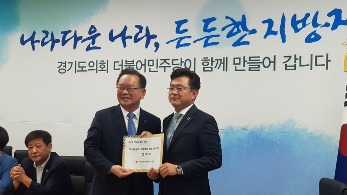 박근철 더불어민주당 대표의원이 지방자치법 전부개정안 등 관련 건의서를 김부겸 당대표 후보에게 전달하고 있다.(사진=경기도의회 제공)