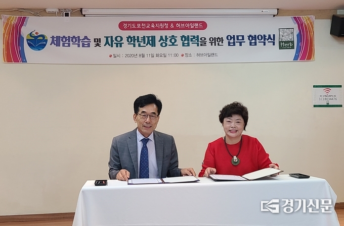 포천교육지원청 심춘보 교육장과 허브아일랜드 임옥 대표(오른쪽)가 협정서에 서명한 후 밝게 웃고 있다. /문석완 기자