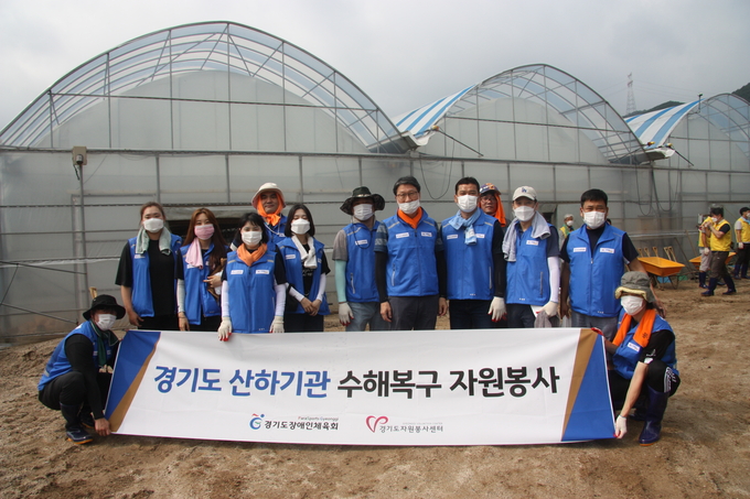14일 용인시 화훼농사 수해 복구활동에 참여한 경기도장애인체육회 임직원들이 기념촬영을 하고 있다. (사진=경기도장애인체육회 제공)