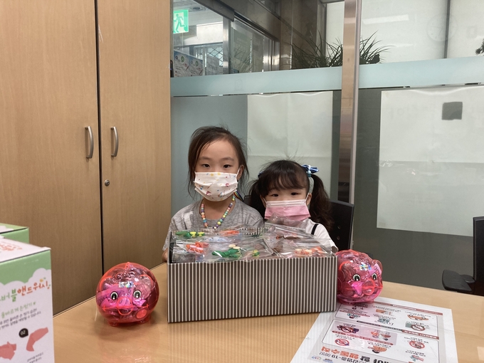 꼬박꼬박 모은 돼지저금통을 들고 동행정복지센터를 찾은 승아(왼쪽), 시아 자매. (사진=부평구 제공)