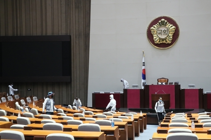 신종 코로나바이러스 감염증(코로나19) 확진자 발생으로 국회가 폐쇄된 26일 밤 방역 관계자들이 국회의사당 본회장에서 방역 작업을 하고 있다. 사진= 연합뉴스 