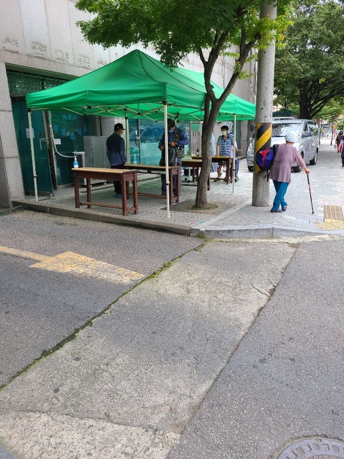 인천시 북성동 인천역 인근에 마련된 무료급식소에서 노숙인과 홀몸노인들이 급식을 도시락통에 담아 가져가고 있다. (사진=김웅기 기자)