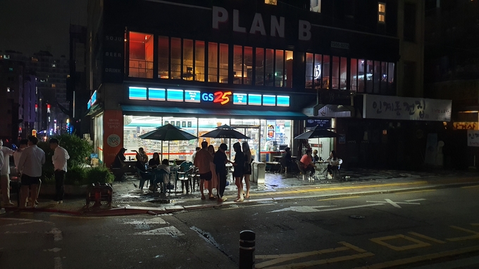 이른바 '수도권의 사회적 거리두기 2.5단계'가 시행된 30일 0시 이후 수원시 팔달구 인계박스의 한 편의점 앞에 마련된 파라솔 테이블에서 사람들이 술을 마시고 있다. (사진=김기현 기자)