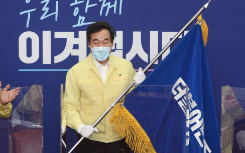  더불어민주당 이낙연 신임 당대표가 31일 오후 국회에서 열린 당기전달식에서 김영주 전국대의원대회 의장으로부터 당기를 전달받고 있다. 사진= 연합뉴스 