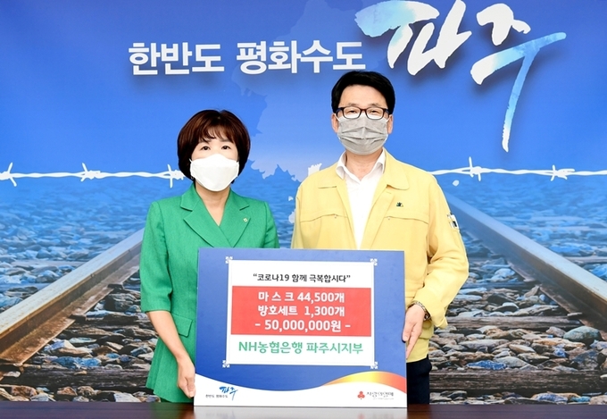 군순옥 NH농협은행 파주시지부장이 최종환 시장께 기부 물품을 전달하고 있다./파주시제공