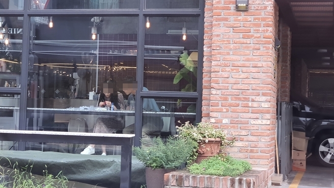 2일 오후 5시쯤 수원 신동카페거리의 한 개인 카페 안에서 손님 2명이 마스크를 쓰지 않은 채 대화를 나누고 있다. (사진=김기현 기자)