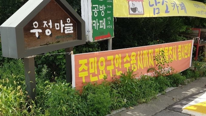 우정마을 곳곳에 개발에 항의하는 플래카드가 게시돼 있다. (사진=박광수 기자)