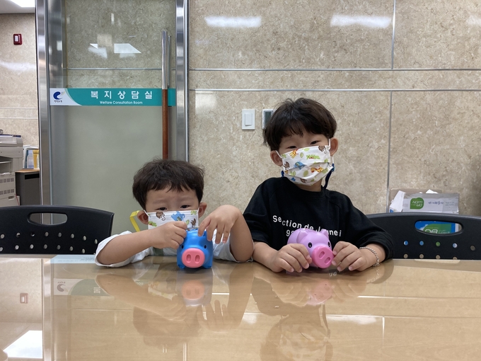 꼬박꼬박 모은 저금통을 들고 동사무소를 찾아 온 김도훈(오흔쪽) 군 형제. (사진=부평구 제공)