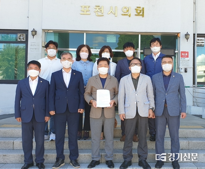 더불어민주당 포천가평 지역위원회 소속 도시군의원들이 성명을 발표하고 포천시의회 건물 앞에서 성명서를 들어보이고 있다. / 더불어민주당 포천가평지역위원회 제공