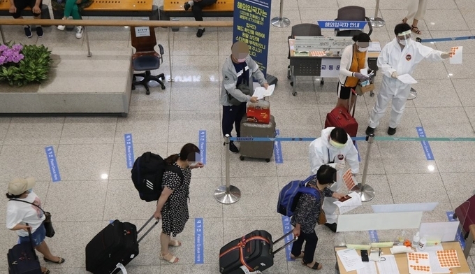 지난 7월 12일 오후 인천국제공항 1터미널에서 입국자들이 해외입국자 교통편 안내를 받고 있다. (사진=연합뉴스)