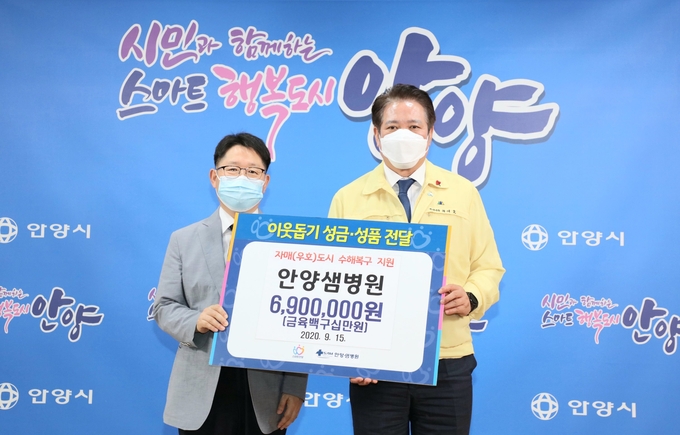  안양샘병원 김용복 원장이 최대호 안양시장에게 결연을 맺고 있는 도시에 전해달라며 수해의연금을 기탁하고 있다./안양시제공