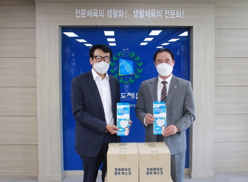 신현필 경기도바이애슬론연맹 회장(왼쪽)이 지난 18일 코로나19로 어려움 겪는 경기도청 직장팀을 위해 써달라고 이원성 경기도체육회장에게 마스크 2,000장을 기부했다. (사진=경기도체육회 제공)
