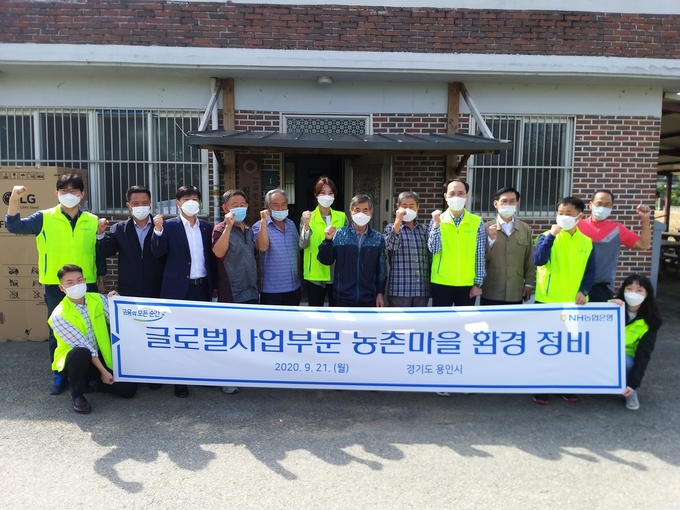 용인시 처인구 원삼면 율곡마을을 찾아 냉장고를 기부하고 마을의 정비 활동을 펼친 NH농협 임직원과 마을 주민들 (사진=농협 용인시지부 제공)