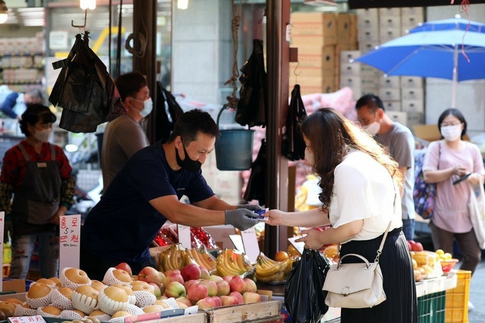 한 도민이 경기지역화폐로 시장에서 물건을 사고 있다. (사진 = 경기도 제공)