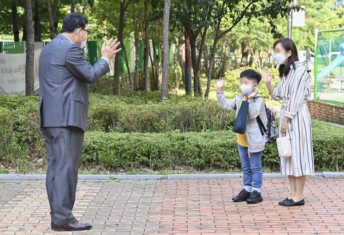 21일 한얼초등학교 교사가 등교하는 학생에 손인사를 하고 있다. (사진=황준선 수습기자)