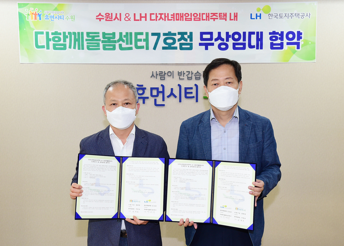 서경보 수원시 복지여성국장(오른쪽), 방명수 LH 주거복지사업처장이 각자 서명한 협약서를 들어 보이고 있다. (사진=수원시 제공)