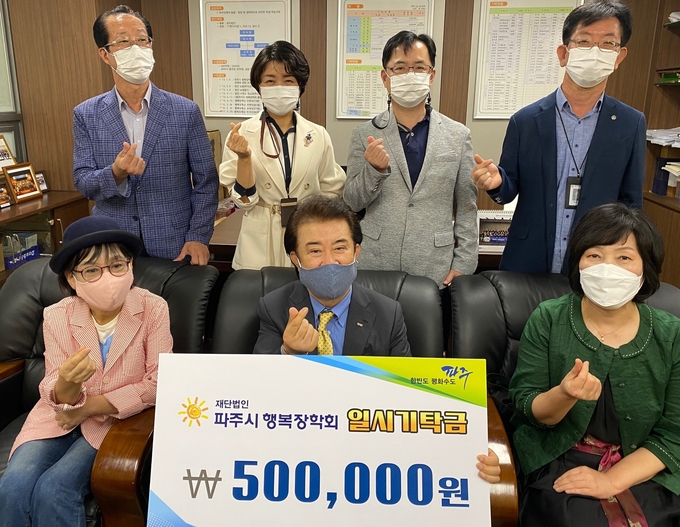 파주 운정3동 마을공동체 관계자들이 장학금을 전달하고 있다. /파주시 제공