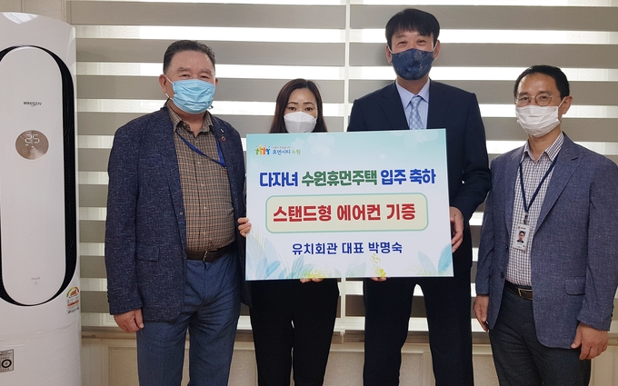 유치회관 직원 노은숙씨(왼쪽 2번째)가 에어컨을 전달하고 기우진 수원시 도시정책실장(오른쪽 2번째) 등 수원시 직원들과 함께하고 있다. (사진=수원시 제공)