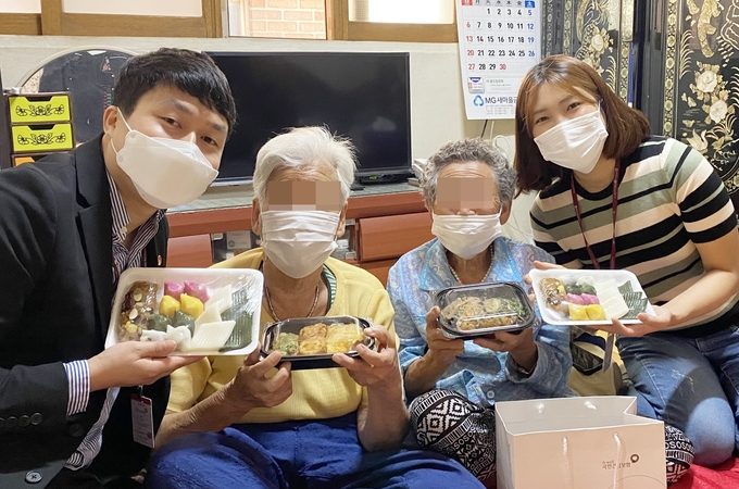 국민건강보험공단 인청경기지역본부 직원들이 독거노인들에게 떡과 송편 등을 전달하고 환하게 웃고 있다. (사진=편지수 기자)
