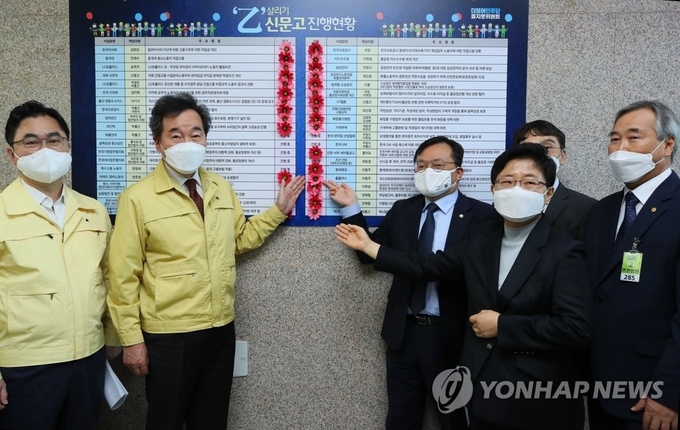 더불어민주당 이낙연 대표(왼쪽 두번째부터), 이동주 의원과 임일순 홈플러스 대표이사, 최소보장임대료 해당 점주들이 5일 국회에서 열린 '을지로위원회 상생 꽃 달기, 최소보장임대(하이브리드계약) 수수료 체계 개선을 위한 대기업 홈플러스와 입점 중소상인간의 상생협력'에서 과제 타결을 축하하며 꽃을 달고 있다. (사진= 연합뉴스) 