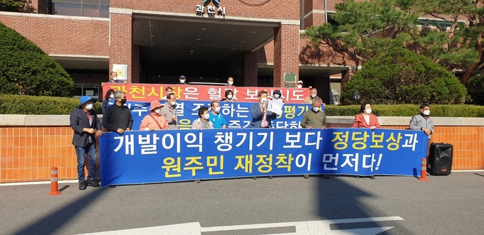과천과천 공공주택지구 토지주 대책위가 과천시가 감정평가사 선정에 개입하지 말 것을 촉구하는 집회를 과천시청 정문 앞에서 열고 있다. 