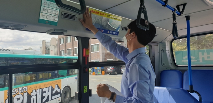 광주경찰서 담당자가 광주시내버스에 불법촬영 범죄의 경각심을 주기위해 버스내에 스티커를 붙이고 있다./광주경찰서 제공