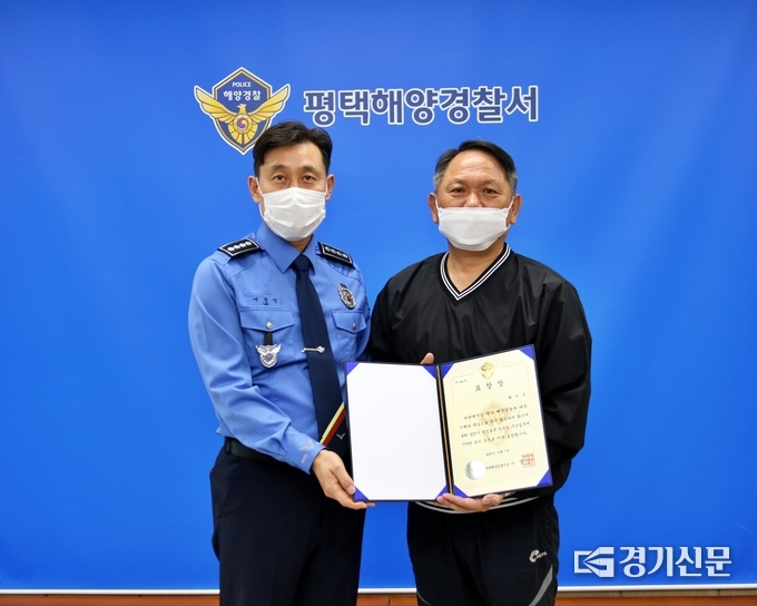 이상인 평택해경 서장(왼쪽)은 충남 한진포구에서 소중한 생명을 구한 황민성씨와 표창 후 기념사진을 찍고 있다. /평택해경 제공