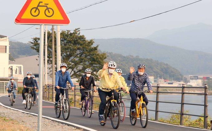 백군기 용인시장과 시 공직자들이 연결 공사가 완료된 경안천 자전거도로를 달리고 있다. /용인시 제공