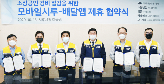 시흥시가 소상공인들의 배달앱 수수료 부담을 2% 이하로 줄이기 위해 지역화폐 모바일시루를 민간 배달앱에서 결제할 수 있도록 제휴 협약을 체결했다. 왼쪽부터 조원행 시흥상생경제협동조합 이사장, 김도형 주식회사 먹깨비 대표, 임병택 시흥시장, 송기선 전국배달라이더협회 회장, 김만걸 ㈜샵체인 대표, 윤문진 허니비즈 대표. /시흥시 제공