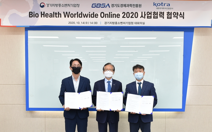 14일 오후 2시 경기중기청 대회의실에서 열린 ‘바이오헬스 월드와이드 온라인 2020 경기도관’의 성공 운영을 위한 업무협약식에서 (왼쪽부터) 이병우 경기KOTRA지원단 단장, 김기준 경과원 원장, 백운만 경기중기청 청장이 협약문을 들고 기념촬영을 하고 있다. (사진=경과원)