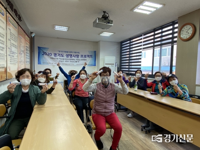 프로그램에 참여한 어르신들이 선물받은 기념품을 들어 보이며 즐거워하고 있다. /포천시자원봉사센터 제공