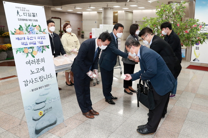 경기도의회 의장단이 취임 100일을 맞이해 백일떡을 출근하는 직원들에게 전달하고 있다(사진=경기도 제공)