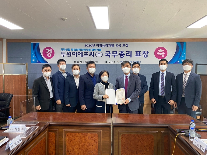 이영화 학장과 황운천 대표가 국무총리 표창장을 들어보이고 있다. /성남폴리텍대학 제공