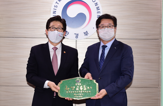 염태영 시장(오른쪽) 조명래 환경부 장관이 환경교육도시 지정 현판을 들고 기념촬영을 하고 있다. (사진=수원시 제공)
