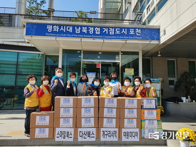 가수 임영웅의 팬클럽인 ‘영웅시대’ 포천·남양주 지역 회원들이 지역 내 아동들에게 전달하기 위해 모은 아동도서 앞에서 기념촬영하고 있다. (사진=포천시 제공)