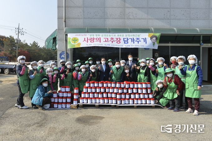 포천시새마을부녀회가 ‘사랑의 고추장 담그기 행사’로 만들어진 고추장 앞에서 기념촬영하고 있다. (사진=포천시 제공)