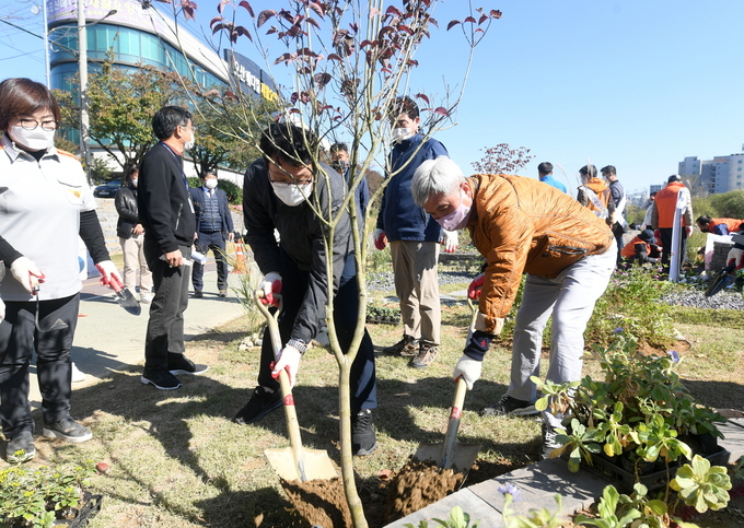 오산시가 ‘2020년 오산천 작은정원 조성 프로젝트’의 일환으로 작은정원 37개소를 추가, 총 88개의 정원을 조성했다. 사진은 곽상욱 오산시장이 작은공원 조성에 식재를 하고 있는 모습. (사진=오산시 제공)