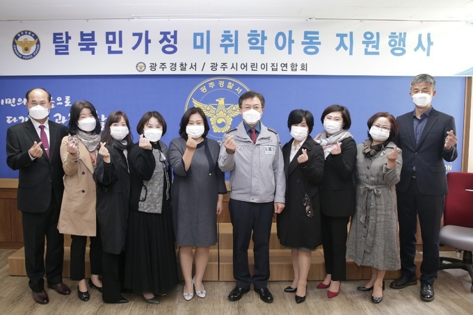 광주시어린이집연합회가 광주경찰서에서 관내 탈북민 가정 미취학 자녀들에게 장학금을 지원하고 기념사진을 찍고 있다.
