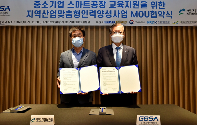 29일 수원시 소재 메리어트호텔 광교 레이크파크볼룸홀에서 열린 ‘중소기업 스마트팩토리교육지원을 위한 지역산업맞춤형인력양성사업 업무협약 체결식’에서 김기준 경과원 원장(오른쪽)과 배수용 경기TP 원장이 협약문을 들고 기념 촬영을 하고 있다. (사진= 경과원)
