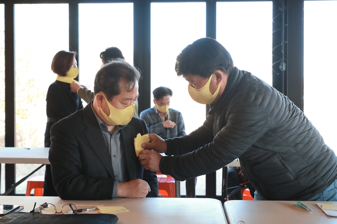 조안면 주민이 노란손수건을 조광한 시장에게 달아주고 있다.(사진=남양주시 제공)