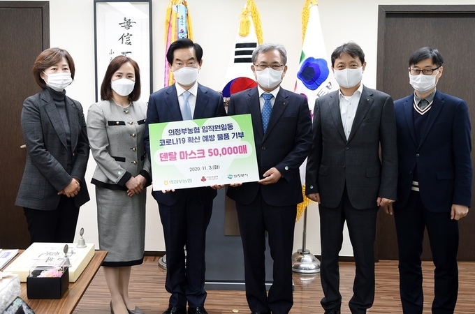 김명수 의정부농협조합장이 안병용 시장에게 마스크를 전달하고 있다.