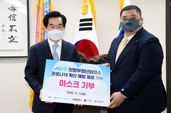 한기현 회장(우측)이 안병용 의정부시장에게 마스크 4만매를 전달하고 있다.