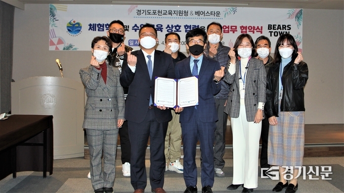 포천교육지원청 심춘보 교육장과 베어스타운 배형진본부장이 협약서를 들어보이며 웃고 있다. (사진=문석완 기자)