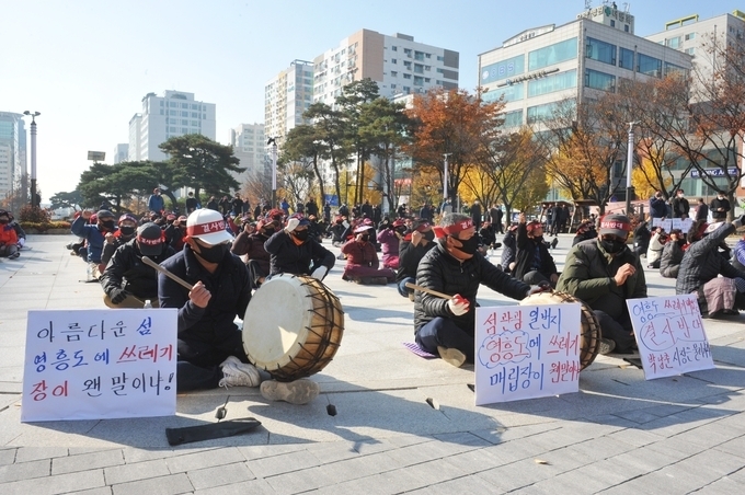 12일 오전 자체매립지 후보지로 선정된 옹진군 영흥도 주민들이 시청 앞에서 ‘계획 철회’를 요구하며 시위를 벌이고 있다. (사진=이재민 기자)