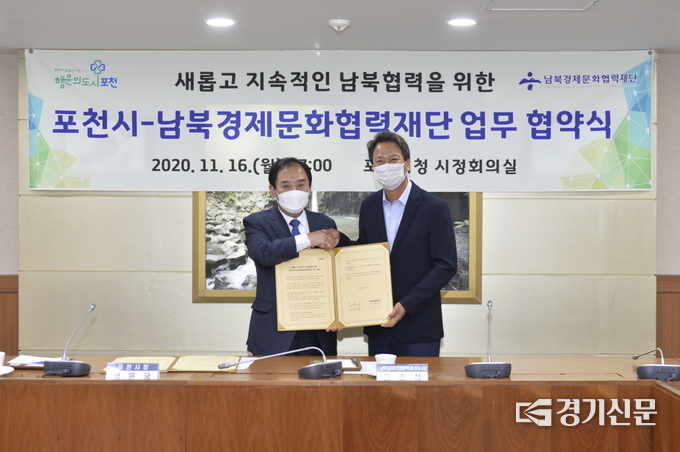 박윤국 포천시장과 경문협 임종석 이사장이 협약서를 들어보이며 악수하고 있다. (사진=포천시 제공)
