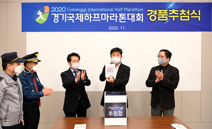 최선욱 경기신문 대표가 18일 경기신문 본사 대회의실에서 언택트 방식으로 열린 '2020 경기국제하프마라톤대회 경품 추첨식'에서 오토바이 m-boy 등 겸품 당첨자를 뽑고 있다. ( 사진 = 조병석 기자)
