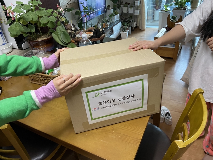 지난 17일 굿네이버스 경기북부지부와 한국도로공사 김포양주건설사업단이 코로나19 긴급구호 물품을 가정에 전달하고 있다. (사진=굿네이버스 경기북부지부 제공)